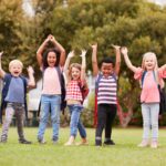 Excited Elementary School Pupils On Playing Field At Break Time